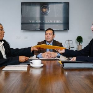 Group of cheerful diverse colleagues discussing court decision at table with notepad and cup