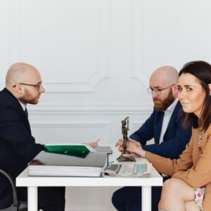 A lawyer consulting a couple in an elegant office setting, focusing on legal matters.